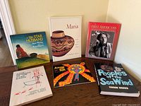 Six books standing on table showing full covers