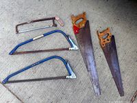 Group shot of five saws on concrete surface