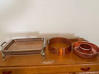 Group shot showing all three items: glass dish in copper stand, copper springform ring, copper bundt pan