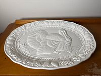 Front view of white ceramic platter showing turkey motif and border detail