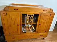 Front view of cabinet showing glass door, side doors, drawers, red details