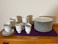 Stack of plates, cups, saucers on purple mat