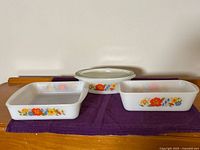 Front view of three Glasbake dishes with lid