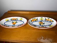 Both oval platters top view showing fruit motif and shape