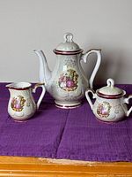 Front view of teapot, creamer and sugar bowl showing design and condition