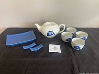 Entire set displayed: teapot, four cups, sushi plate, two rests