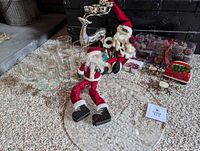 Group shot of all items on carpet including platter, goblets, reindeer candle holder, Santas, snowflake holders, napkin holder, berry ornaments