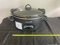 Front view showing brand logo, control panel and tape measure for scale