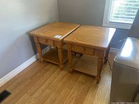 Two matching honey oak end tables beside sofa