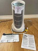 Front view of Honeywell QuietClean tower air purifier with manuals displayed on floor