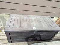 Top view of closed Keter deck box showing slatted lid and lock hasp