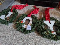 All three wreaths spelling JOY laid out together