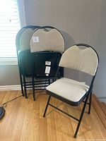 Group of four matching folding chairs, three folded one open