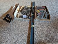 Overview of hand saw, 48" level, two boxes of nails/plates