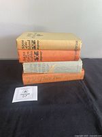 Stack of four hardcover books showing spines