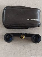 Opera glasses with case, Bushnell logo visible