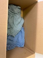 Grey and light blue shirts at bottom of box