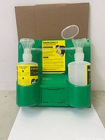 Front view of green wall station with two eye wash bottles and instruction card