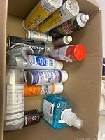 Top view of box showing multiple aerosol cans, Gojo soap and spray bottle
