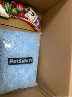 Bag of PetSafe blue crystal litter and catnip toys in box