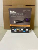 Front view of retail box showing Roku Streaming Stick+ with remote and 4K HDR features