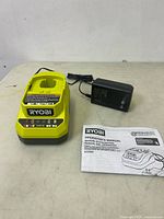 Top view of Ryobi charger base, AC adapter, and manual