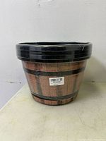 Stacked plastic barrel-style plant pots wrapped in plastic