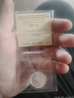 Front view of ICCS-sealed 1968 silver quarter showing coin obverse and certification insert