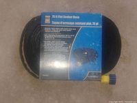 Front of packaged 75 ft flat soaker hose showing product name and coupling