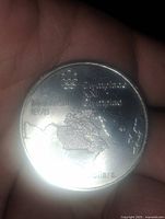 Reverse showing map of North America, Olympic rings logo, legends Montreal 1976 5 Dollars