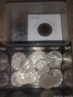 Top view of plastic box showing loose Canadian nickels and 1945 Victory nickel in flip