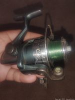 Overall view of South Bend spinning reel showing body, spool with green line, bail arm and handle