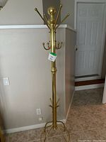 Full view of brass-tone coat/hat rack showing height and overall design