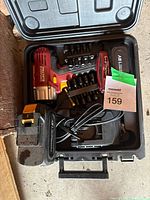Open carrying case showing drill, charger, bits, battery, folding tool
