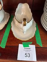 Side view of gravy boat on underplate showing gold gilt trim