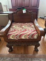 Front view of carved wood armchair with patterned cushion