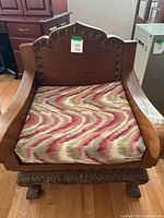 Front view of carved hardwood armchair with cushion