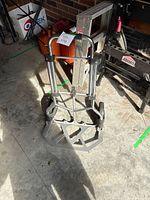 Full view of aluminum folding hand truck standing on concrete floor