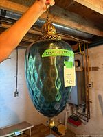 Full view of pendant lamp showing glass globe, metal cap, pull chain