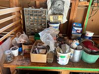 Workbench view showing drawer cabinet and multiple boxes and tubs of hardware