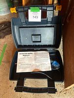 Open case showing empty accessory tray and manual