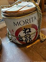 Front view showing Morita branding, straw wrapping, rope, partial lid