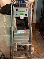 Front view of folded Reynolds aluminum step ladder showing tray and feet