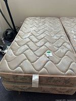 Top view of twin mattress atop box spring showing floral pattern and overall condition