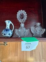 Glass bottles and Delft pitcher arranged on wooden surface