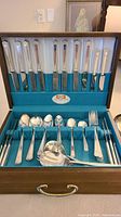 Chest open showing complete flatware set and serving pieces
