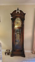 Full frontal view of the mahogany grandfather clock showing overall design and condition