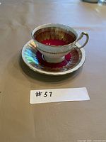 Teacup on saucer, front angle showing color scheme and gold trim