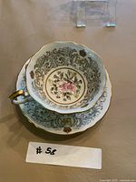 Teacup nested in saucer showing interior floral design and ER monogram