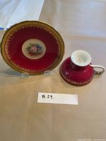 Teacup inverted beside saucer on stand showing colour, pattern and scale